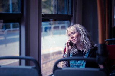 Genç kadın şehir tren cep telefonunda söz. 