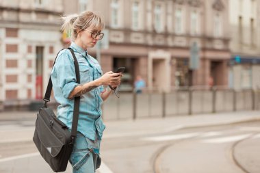 Genç kadın manifatura üstünde hareket eden telefon kentin açık atış.