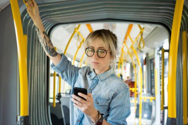 Genç hipster kadın manifatura şehir tren cep telefonunuzda.