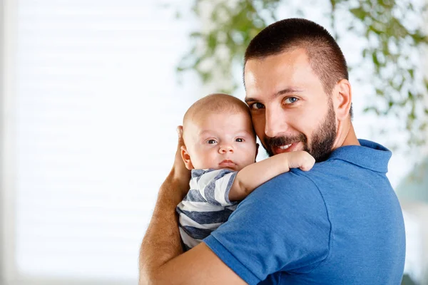 Feliz Padre Joven Sosteniendo Bebé Casa Sonriendo Cámara — Foto de Stock