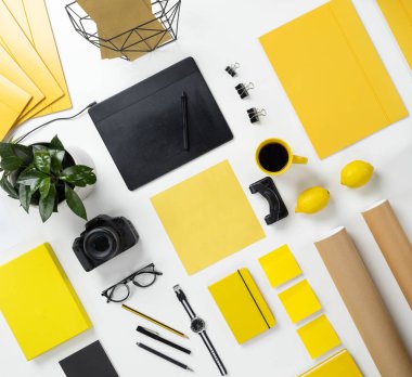 Beyaz arka plan üzerinde üst görünümden sarı ve siyah nesneleri ve Kırtasiye grubunun. Kamera, gözlük, kağıt, not defteri. Fotoğrafçı Danışma. Sırayla.