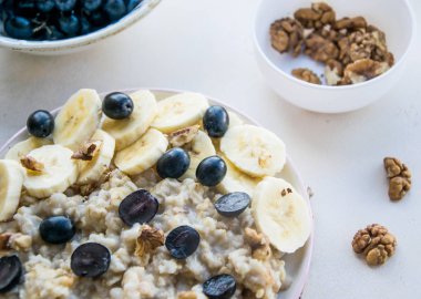 Açık renkli. Taze meyve yulaf ezmesi. Muz dilimleri, kara üzüm ve fındık