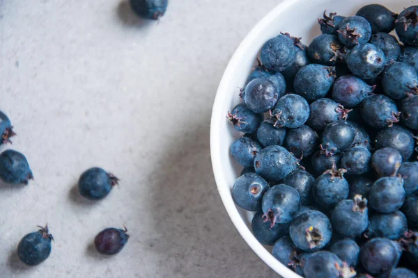 A good summer.Light background, seasonal blueberries in a cup. berry placer