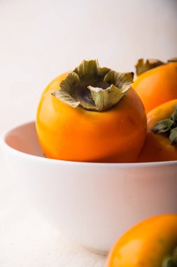 beyaz bir fincan parlak Trabzon hurması