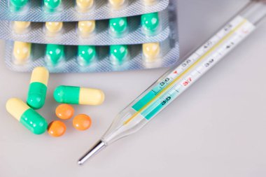 Tablet, saf su, bir termometre. Beyaz bir arka plan üzerinde.