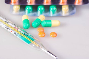 Tablet, saf su, bir termometre. Beyaz bir arka plan üzerinde.