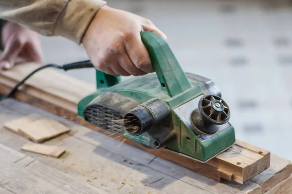 Manual manufacturing of furniture from a natural tree in a workshop.