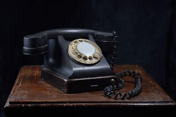 一个黑色的旧手机 在一个旧的 木制的桌子特写镜头 图库图片