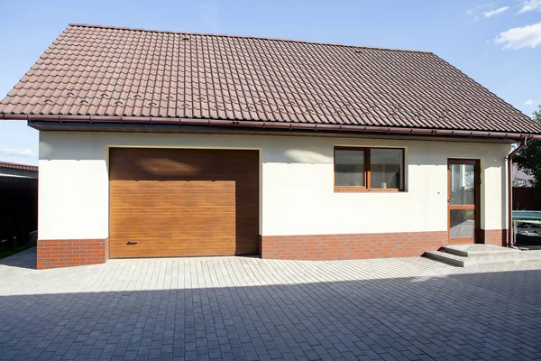 Garaj bahçe evi. Yana kayar. Sıcak güneşli gün. Kaldırım döşeme