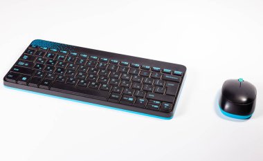 Kablosuz klavye ve fare beyaz masaya vardır. Beyaz arka plan.