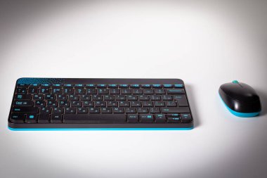 Kablosuz klavye ve fare beyaz masaya vardır. Beyaz arka plan.