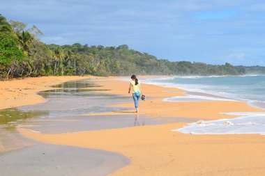 BOCAS DEL TORO, PANAMA - 3 Mart 2018: Bluff Beach 'te yürüyen kız.