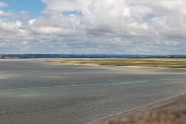 Lagün harika bulutlar ile düşük gelgit. Mont-Saint-Michel, Normandiya, Fransa