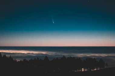 Bulutların üzerindeki C / 2020 F3 (NEOWISE) kuyruklu yıldızının görüntüsü