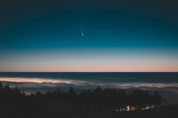 Bulutların üzerindeki C / 2020 F3 (NEOWISE) kuyruklu yıldızının görüntüsü