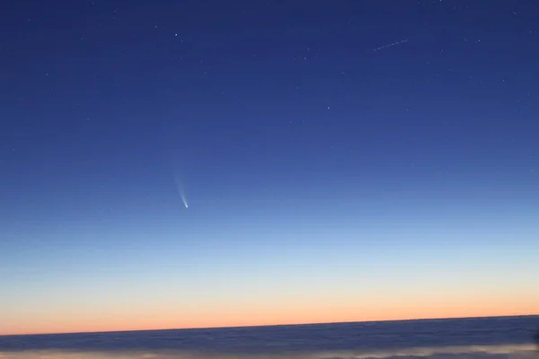 Bulutların üzerindeki C / 2020 F3 (NEOWISE) kuyruklu yıldızının görüntüsü