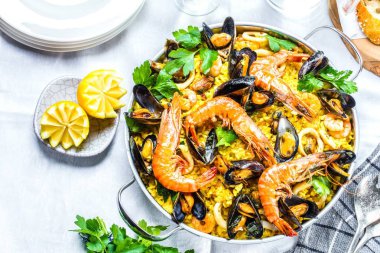 Geleneksel deniz ürünleri paella eski ahşap bir masa üzerinde tavada
