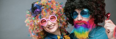 Mutlu bir adam ve renk peruk partisi öğelerle giyen kadın