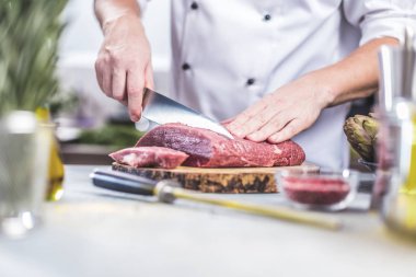 Yemek restoran mutfak şefi, o et veya biftek kesiyor 