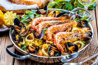 Geleneksel deniz ürünleri paella eski ahşap bir masa üzerinde tavada