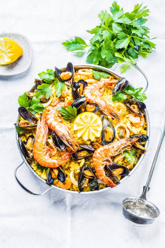 Traditional seafood paella in the pan on a wooden old table