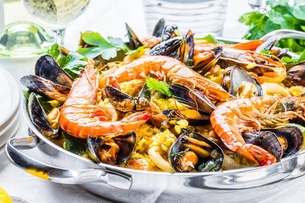 Traditional seafood paella in the pan on a wooden old table