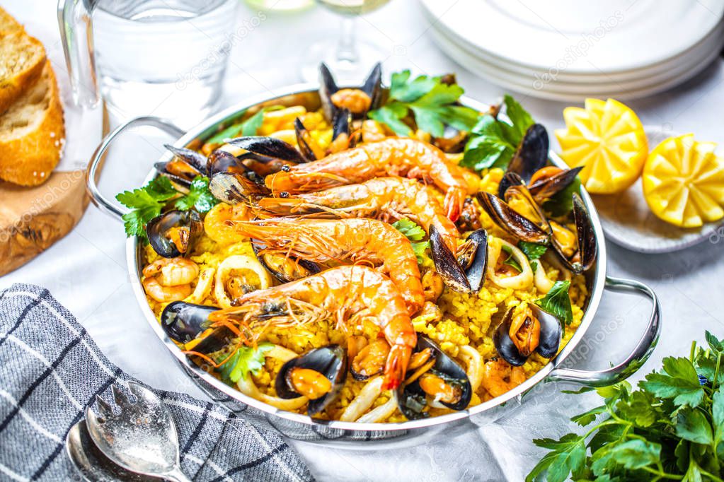 Traditional seafood paella in the pan on a wooden old table