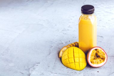 Düz-lay şişelerde taze tropikal meyve ve beton zemin üzerine superfoods ile renkli smoothies