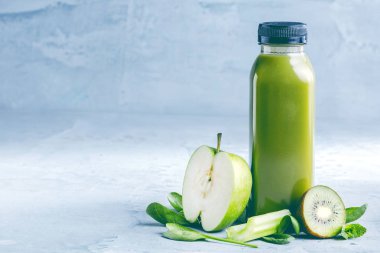 Düz-lay şişelerde taze tropikal meyve ve beton zemin üzerine superfoods ile renkli smoothies