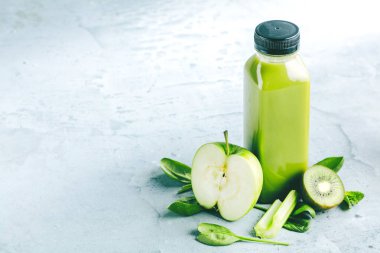 Düz-lay şişelerde taze tropikal meyve ve beton zemin üzerine superfoods ile renkli smoothies