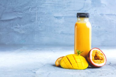 Düz-lay şişelerde taze tropikal meyve ve beton zemin üzerine superfoods ile renkli smoothies