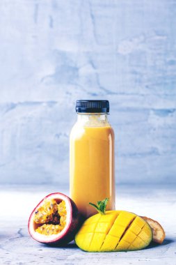 Düz-lay şişelerde taze tropikal meyve ve beton zemin üzerine superfoods ile renkli smoothies