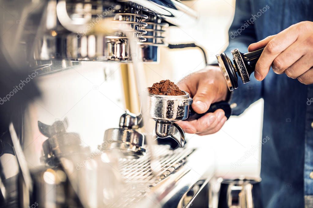  Barista using coffee machine for making coffee in the cafe