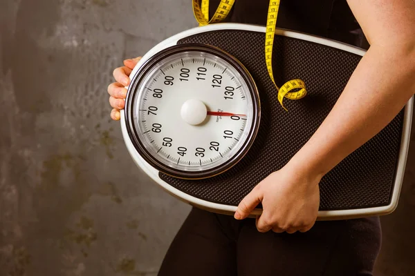 食事と体重のスケールを持つ若い女性 — ストック写真