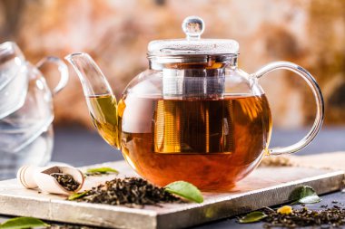 Taze demlendi siyah çay, sıcak yumuşak ışık, koyu arka plan.