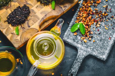 Taze demlendi siyah çay, sıcak yumuşak ışık, koyu arka plan.