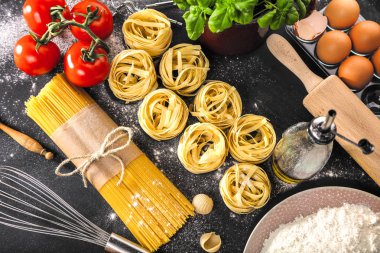 Koyu arka plan üzerinde malzemelerle İtalyan Makarna