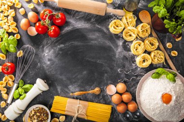 Koyu arka plan üzerinde malzemelerle İtalyan Makarna