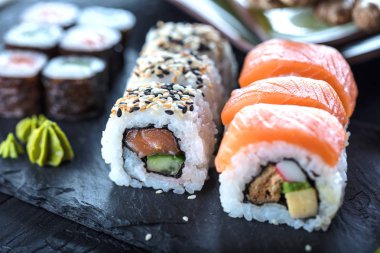 Suşi Sashimi ve suşi ruloları taş levhada servis edilir.