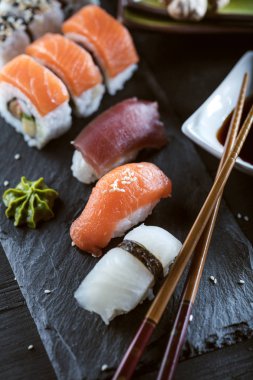 Suşi Sashimi ve suşi ruloları taş levhada servis edilir.