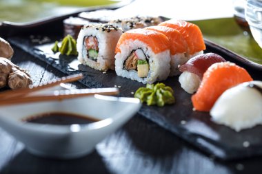 Suşi Sashimi ve suşi ruloları taş levhada servis edilir.