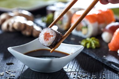 Sushi Set sashimi and sushi rolls served on stone slate clipart