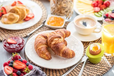 Breakfast served with coffee, orange juice and croissants clipart