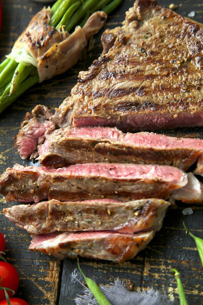 Fresh grilled meat. Grilled beef steak medium rare on wooden cutting board. Top view.