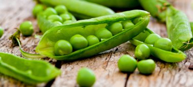 Hearthy taze yeşil bezelye ve bakla rustik ahşap zemin üzerine