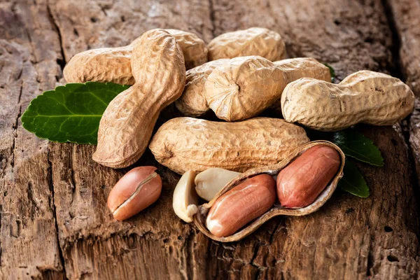木材の背景上のシェルでピーナッツ — ストック写真