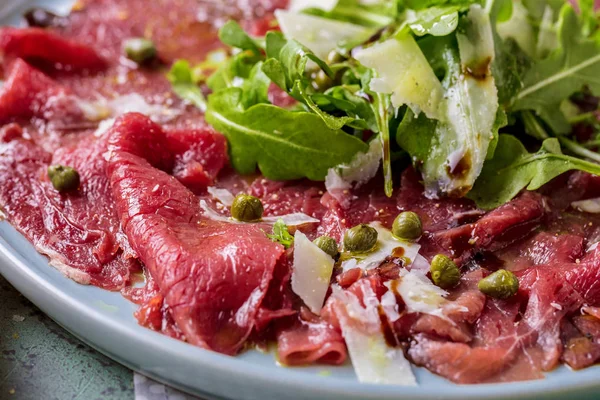 Dana carpaccio hardal ve parmesan ile siyah plaka üzerinde