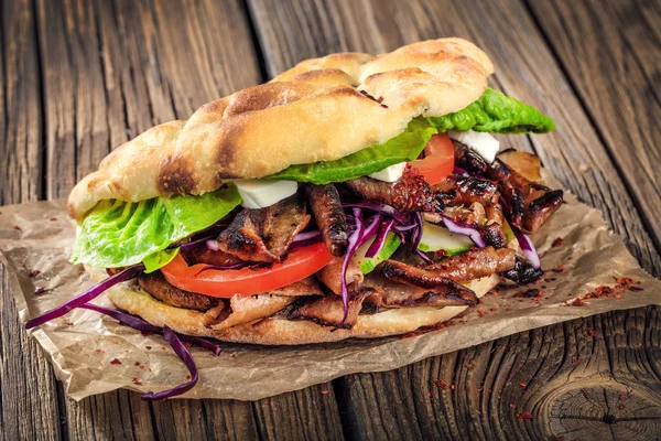 close up of kebab sandwich on wooden background