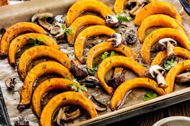 Fırında pişirme kağıdı üzerinde şekerli kabak dilimleri pişmiş. Sağlıklı gıda