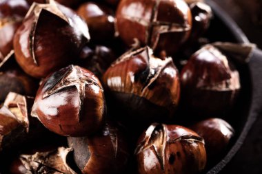 Eski ahşap masa üzerinde özel delikli tavada kavrulmuş kestane